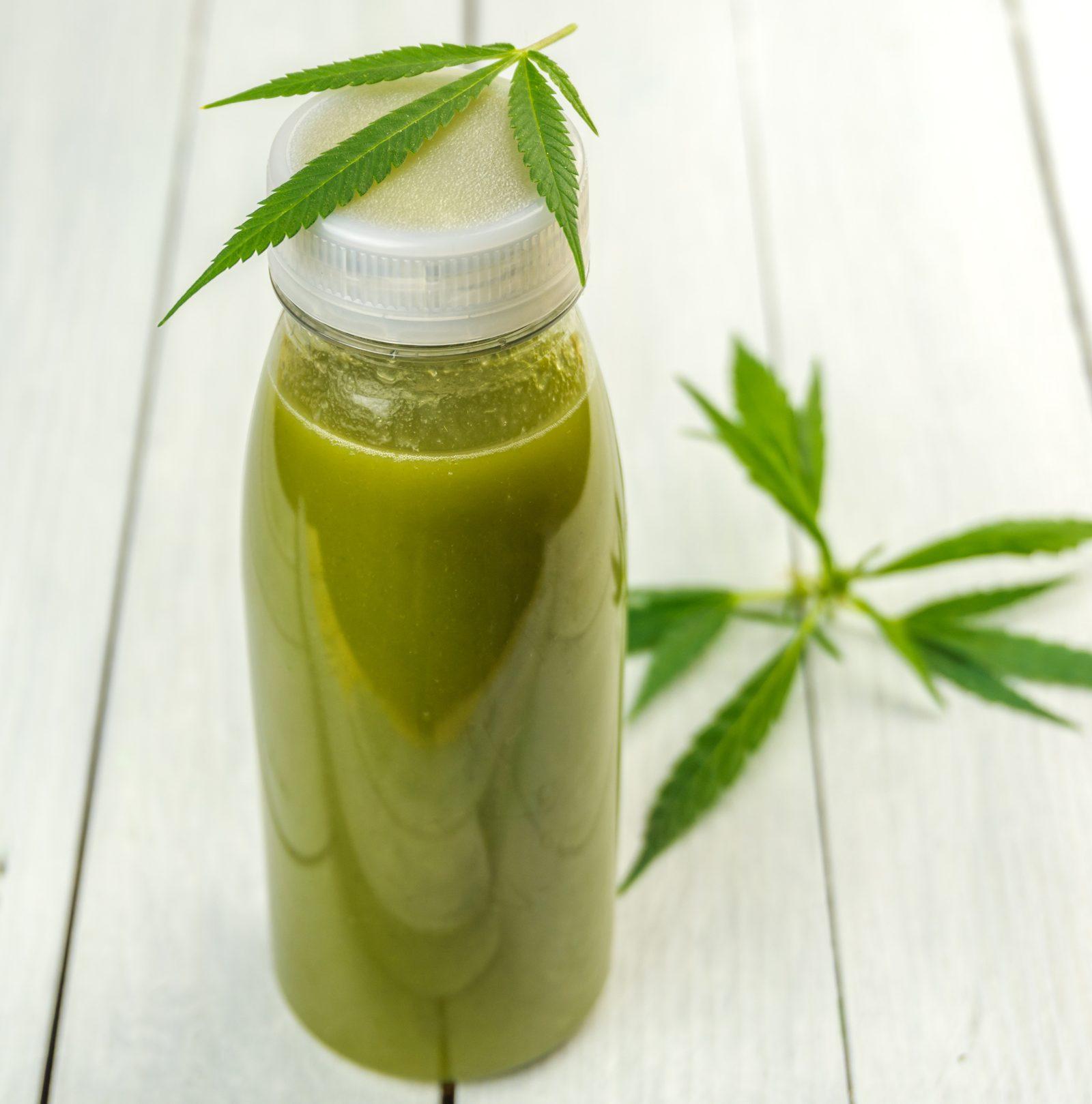 Green smoothie in clear bottle with green leaves